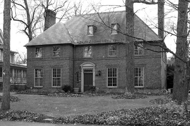 1106 West Forest Road, a brick Georgian style home, has a steeply pitched flat top hipped foor and paired end chimneys