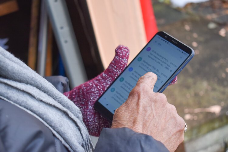 Garfield Heights resident Janet Gill-Cooks scrolls through her phone, showing this reporter the emails she’s sent in her quest to find assistance for her utility bills.