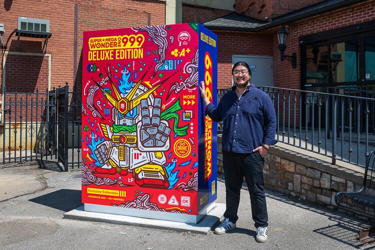 Artist Jordan Wong (WONGFACE) with his latest creation—a Little Free Library and public art piece, “Super Mega Wonder 1999,” located outside Asia Town Center at 3820 Superior Ave.