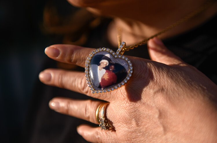 <span class="content-image-text">Kevina Chapolini holds up a necklace with a photo of herself and her husband who died last year following a battle with cancer, from which Chapolini is also a survivor.</span>