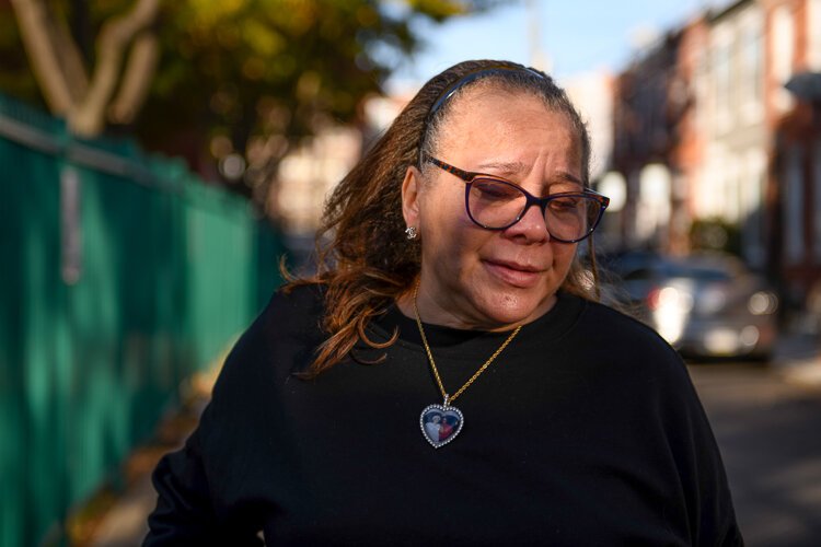 Kevina Chapolini becomes emotional while talking about her husband who died last year from ccancer, whlie standing down the street from her home in Philadelphia