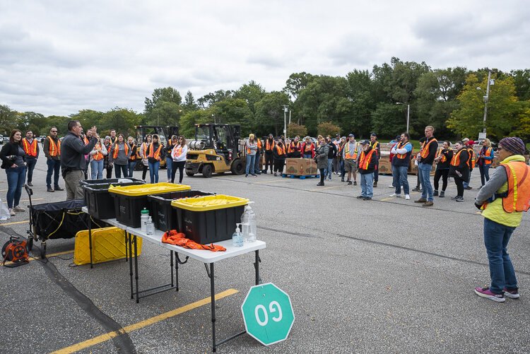 Volunteers assemble for directions to distribute food at the Cleveland Muni Lot for the Cleveland Food Bank Mobile Pantry Program