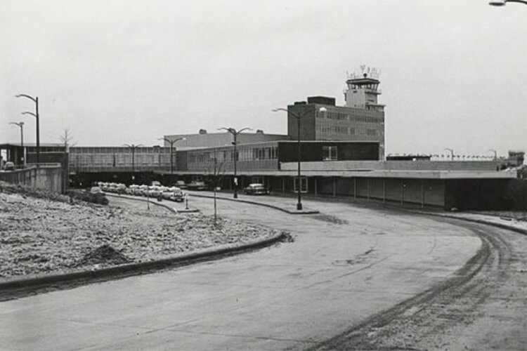 Taxi cabs lined up in front of the airport's terminal building. 1950’s