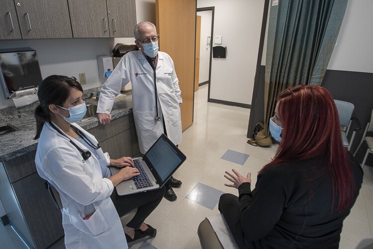 <span class="content-image-text">UH COVID Recovery Clinic medical director David Rosenberg, far right, and staff member Juliane Torer, Internal Medicine Nurse Practitioner talk with a Long Covid patient at University Hospitals COVID Recovery Clinic in the Risman Pavilion</span>