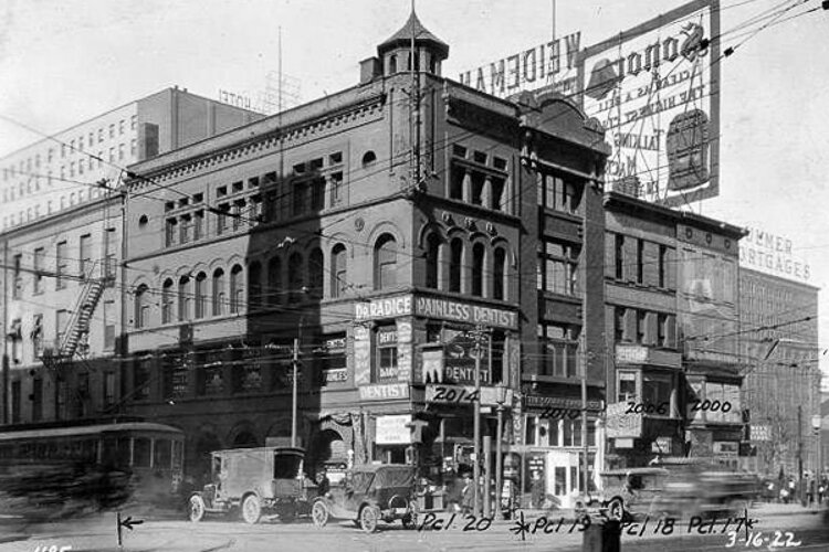 Northwest corner of Champlain St. and Ontario St. showing May's Drug Store, a soda grill, Clothing on Credit, Square Baking Co., Bake Rite Donut Co., office of John Radice, DDS. and a lunchonette on the corner - 1922