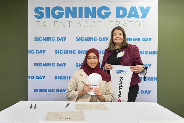 <span class="content-image-text">Yasmin Abdul-Khaliq (left) signed her acceptance letter to work as a consultant for her apprenticeship sponsor, Key Bank. She is pictured with KeyBank’s Cyber Defense Center director, Jennifer Zacharias (right).</span>