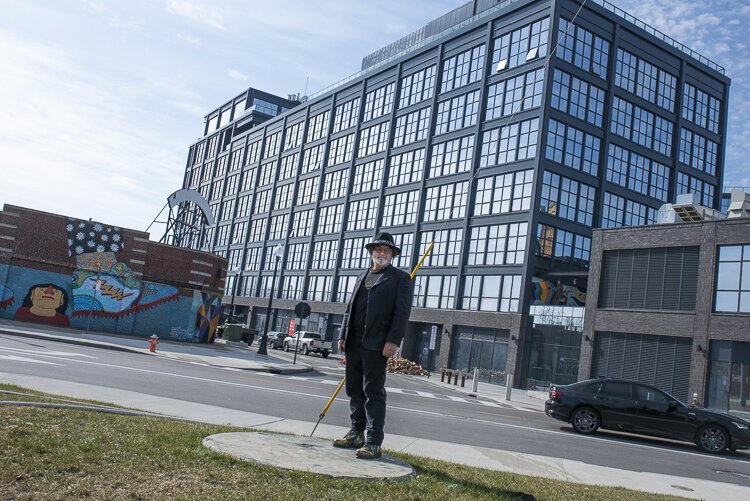 Artist Loren Naji at the location where his "They Have Landed"orb sculpture stood with the newly built Intro building in the background