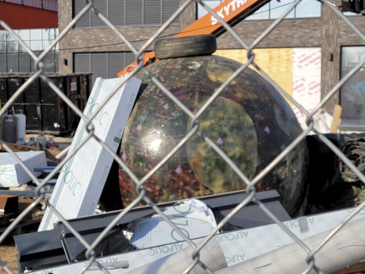 Loren Naji’s "They Have Landed" orb sculpture during the Into building construction disrespected and covered in debris