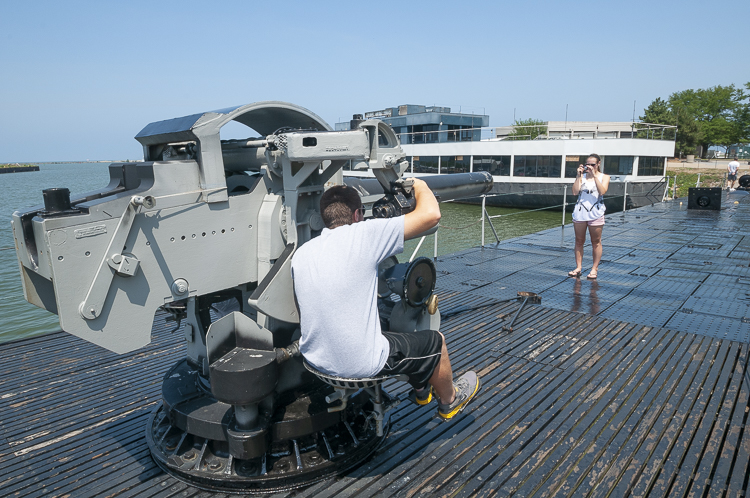 Visitors posing with the deck gun on the USS COD