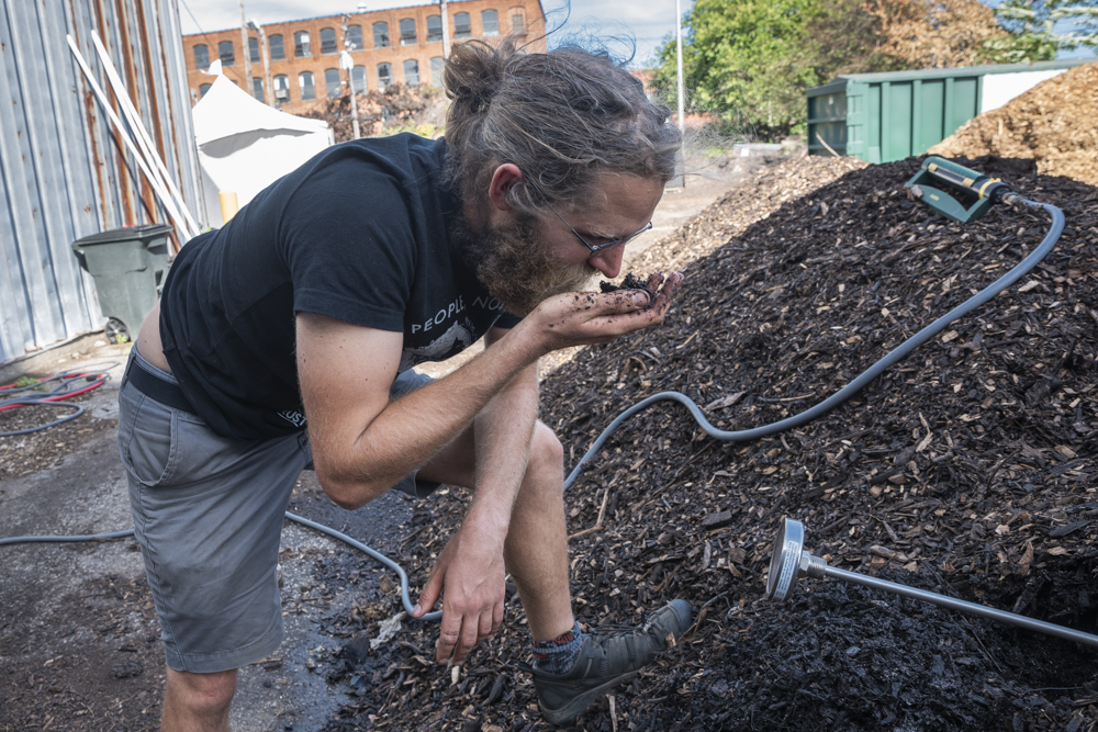 Nathan Rutz of Rust Belt Riders checking the compost pile