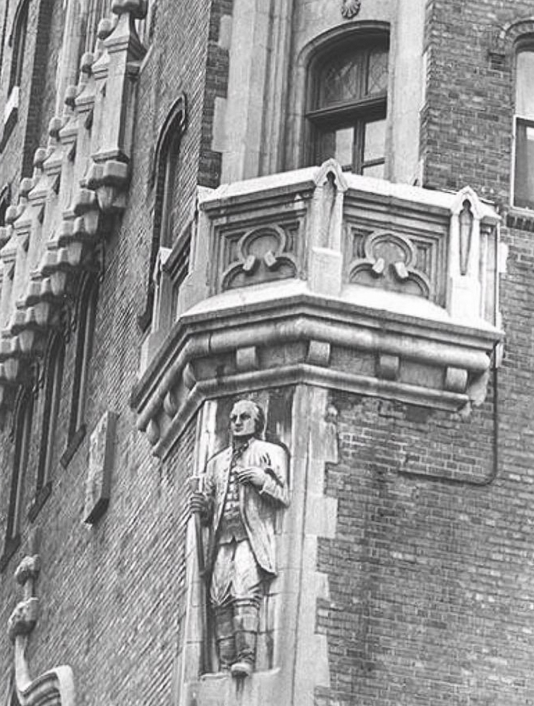 The figure of Moses Cleaveland carved into a corner near the top of the Tudor Arms Hotel, ca. 1966