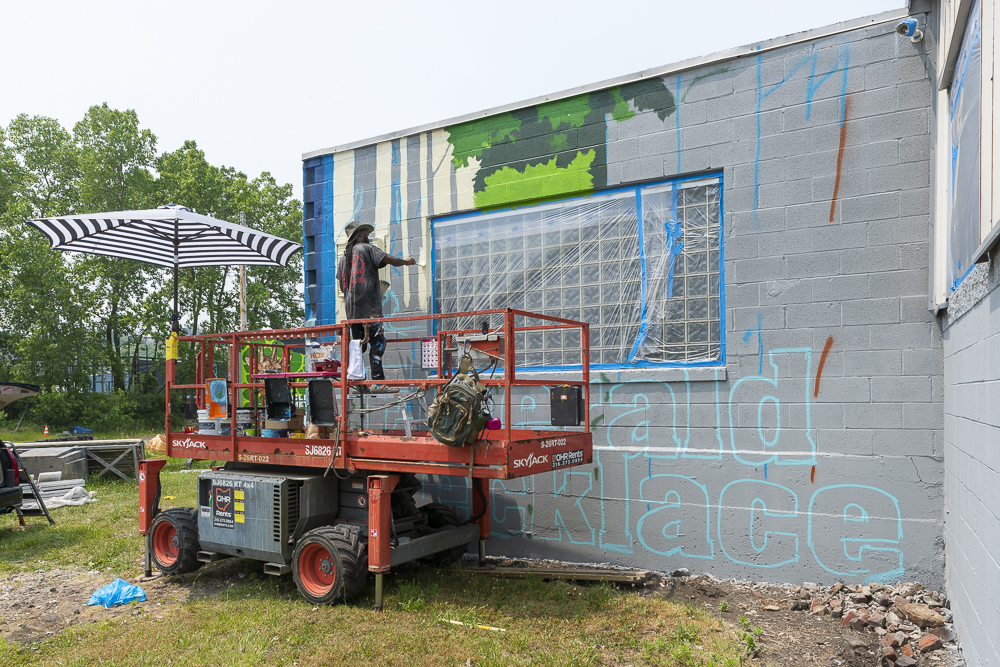 Isaiah Williams painting his Emerald Necklace mural