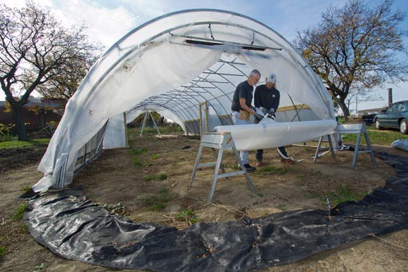 <span class="content-image-text">Carlton Jackson and Todd Alexander, co-owners of Tunnel Vision Hoops working on a hoop house in Ohio City</span>