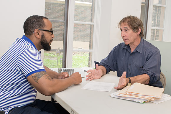 James Levin working with a client in his office at the Famicos Foundation