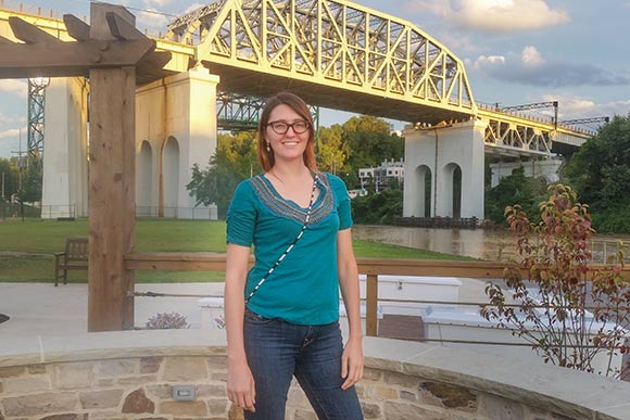 Rotary volunteer Alexis Kim at Merwin’s Wharf with the Cuyahoga Viaduct and Bridge in the back ground