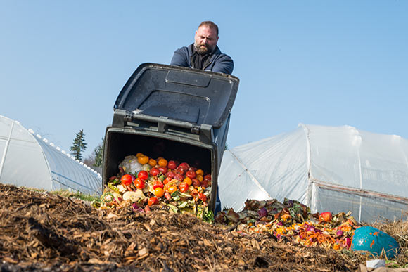 Chris Bond, Farm Horticulturist at CWRU Squire Valleevue Farm empties the waste brought in for composting