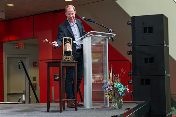 Christopher Gergen, co-founder of Forward Cities ringing the City Club bell to start the meeting