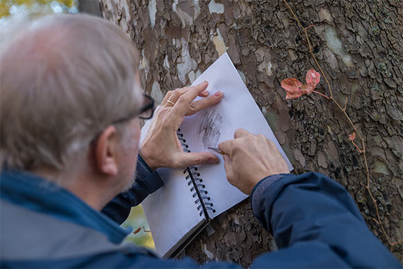 Douglas Paige making a tree bark rubbing in his field notebook