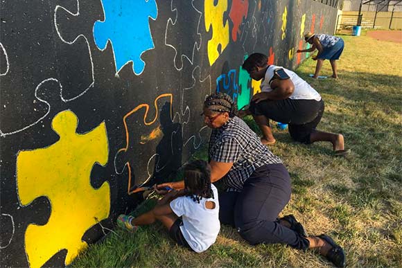 Volunteers putting the Chelton Park mural project pieces together