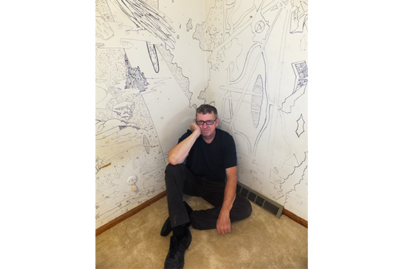 Derf by the mural he drew on the walls of his bedroom as a teen