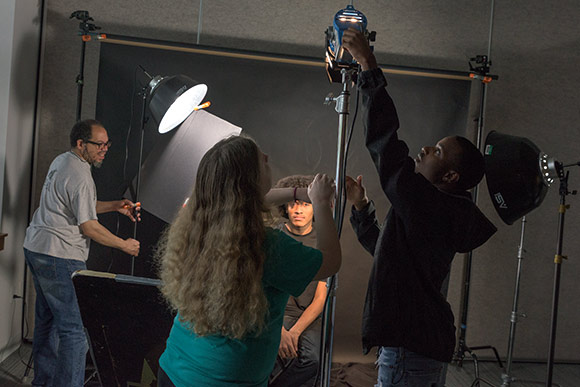 <span class="content-image-text">Instructor Robert Banks works with photography students in the NewBridge after School program</span>