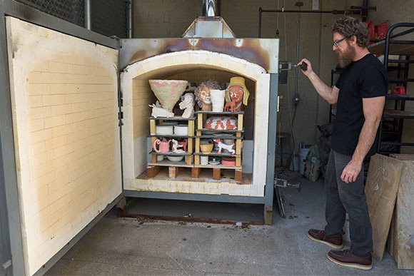 Ceramic instructor Billy Ritter getting ready to fire student work for the Spring Session Exhibition