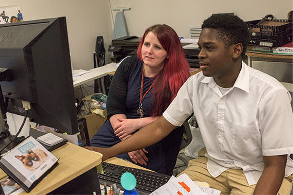 <span class="content-image-text">Instructor Natalie Eddy works with a graphic design student in the NewBridge after School program</span>