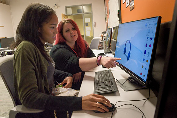 Instructor Natalie Eddy works with a graphic design student in the NewBridge after School program