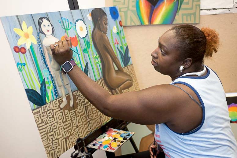 <span class="content-image-text">Artful Cleveland artist, LaSaundra Robinson works on painting in her studio</span>