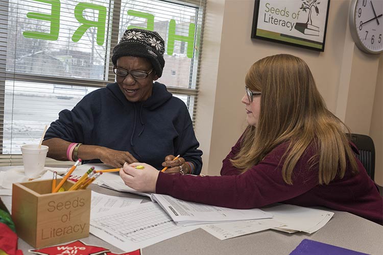 <span class="content-image-text">Site coordinator Kara Krawiec, helps out a Seeds of Literacy student</span>