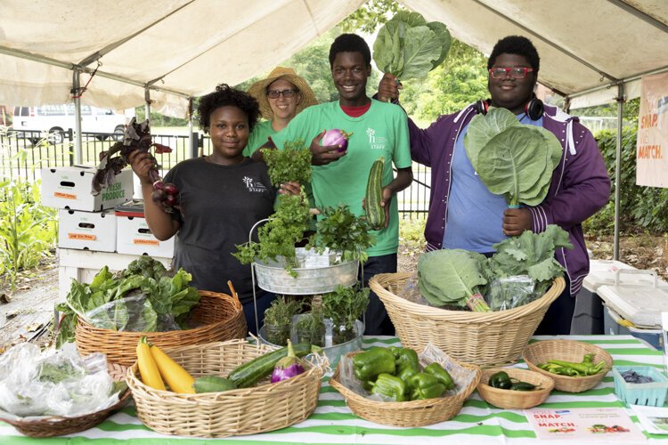 Student workers at the Fairfax Learning Farm show off the results of their hard work.