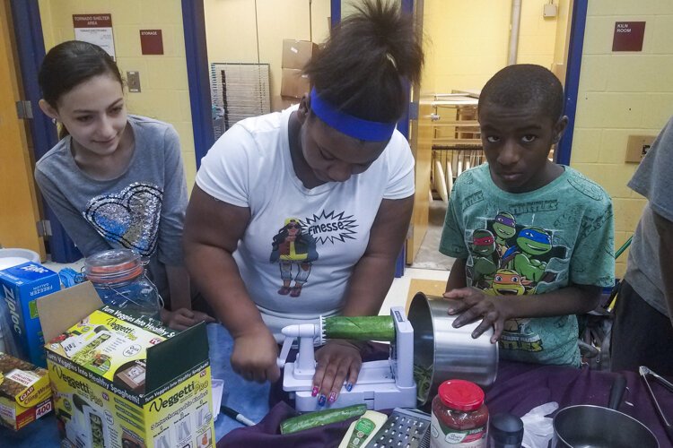 Kids take part in a Food Strong program, preparing a meal.