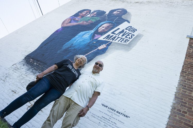 Gary Williams and Robin Robinson with “Our Lives Matter,” a mural at East 105th St. and Yale Ave.