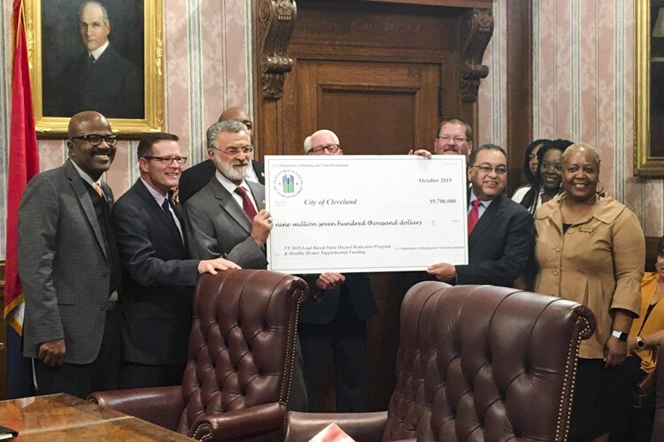 <span class="content-image-text">Mayor Frank Jackson stands with Joseph Galvan, regional administrator of the U.S. Department of Housing & Urban Development, and Kevin Conwell, Ward 9 councilman, to receive a check for $9.7 million for Cleveland’s lead crisis.</span>