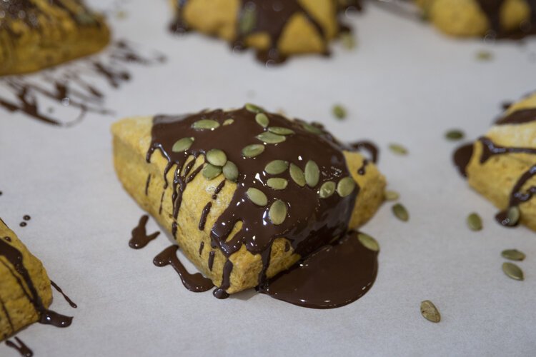 Baba Yaga’s Vegan Pumpkin Scone with chocolate ganache drizzle and pumpkin seeds.