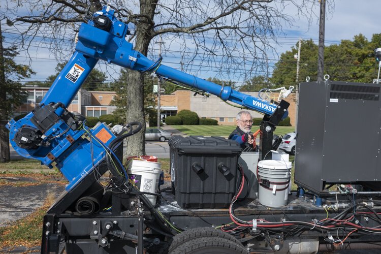 Sam Bell sets the robotic arm into travel position.