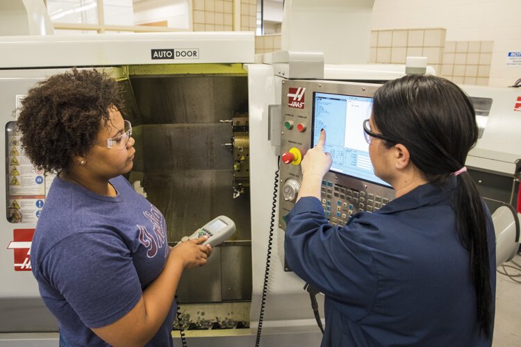 An instructor at Cuyahoga Community College (right) works with a student on codes.