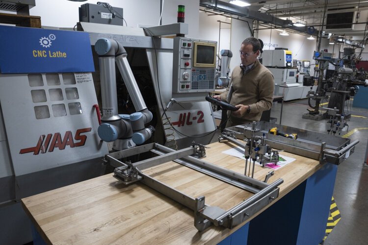 Matthew Fieldman, vice president of external affairs for MAGNET, operates a collaborative robot that eliminates boring, repetitive, and generally low-skilled jobs, letting people focus on more challenging work.