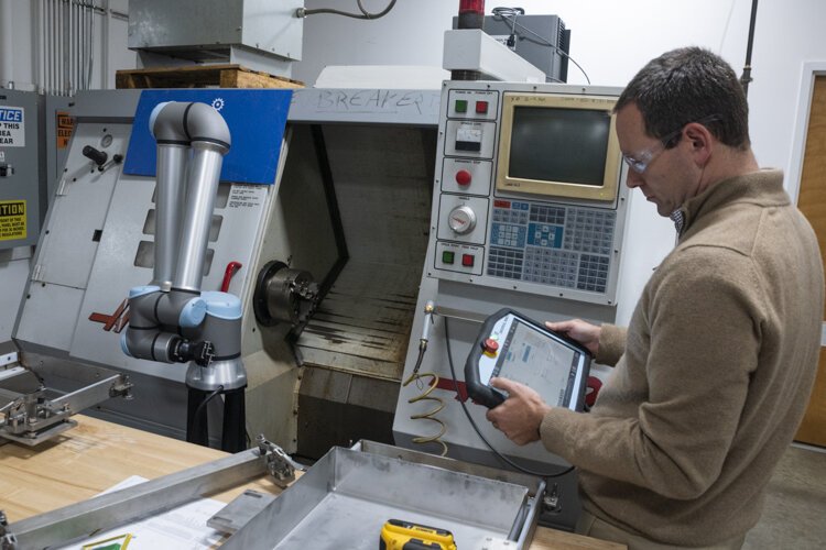 <span class="content-image-text">Matthew Fieldman, vice president of external affairs for MAGNET, operates a collaborative robot that eliminates boring, repetitive, and generally low-skilled jobs, letting people focus on more challenging work.</span>