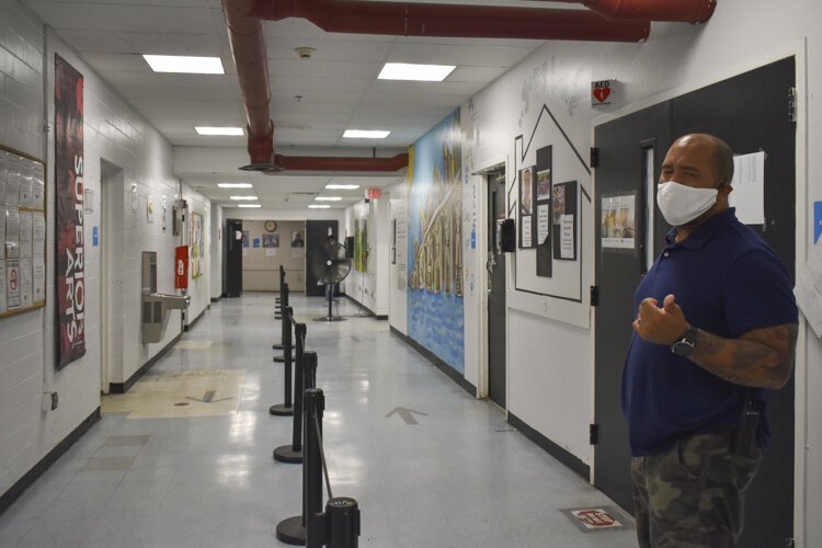 David Blunt shows how the hallways are demarcated into two lanes to reduce contact between people walking through the shelter.