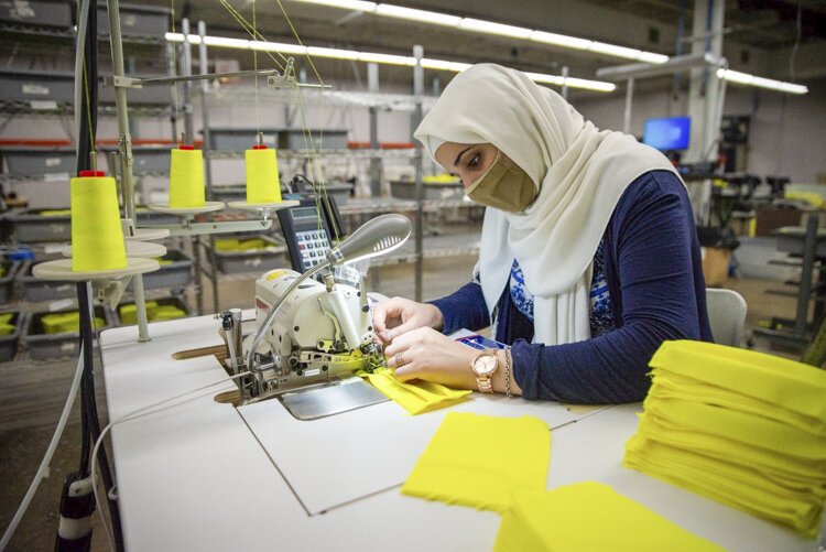 Nadia Akhlif sews a mask at National Safety Apparel as part of the company's pivot to creating face masks and gowns to fight the coronavirus.