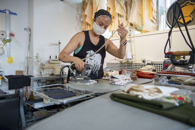 <span class="content-image-text">Valerie Mayen, owner of Yellowcake Shop, organizes an order of face masks inside her store in 78th Street Studios.</span>