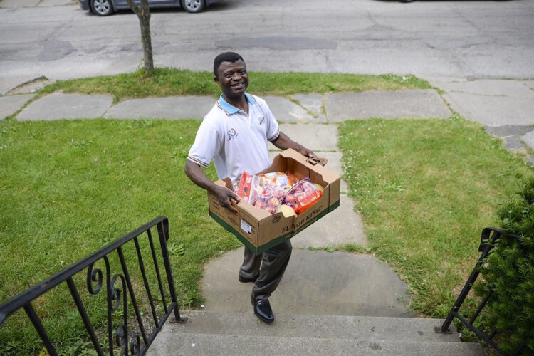 Elijah Kidjana, President of the Congolese Community of Greater Cleveland, distributes food to neighbors on June 11th.