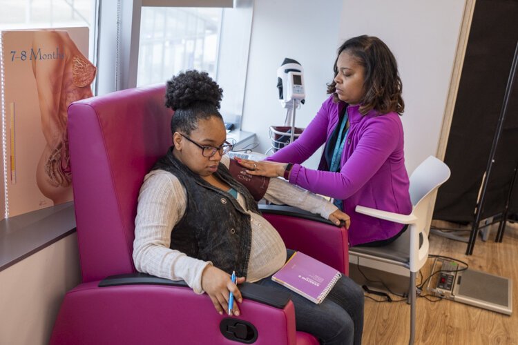 Santiana Huggins LPN, facilitator for the CenteringPregnancy program, checks the blood pressure of a mommie-to-be.