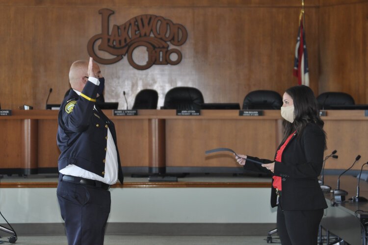 <span class="content-image-text">A police officer being sworn in by Mayor George.</span>