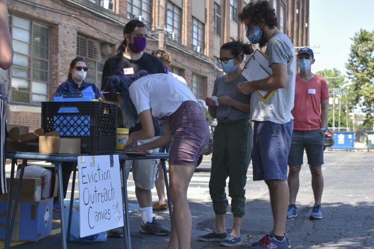 Members of the Cleveland DSA chapter meet at a parking lot near downtown Cleveland on a Saturday morning, preparing to head out to dozens of rental homes where tenants are at risk of being evicted.