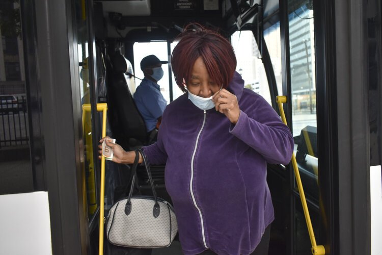 <span class="content-image-text">Gail Cox, of Tremont, gets off a Greater Cleveland RTA bus after it arrives in downtown Cleveland where she works as a cashier at a store nearby and uses the bus regularly during the pandemic, despite her concerns that other riders do not always wear</span>