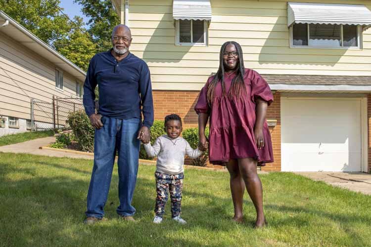 Miles Hackney, great-grandson Dom Hudnall, and granddaughter Leah Hudnall outside Miles_ home on East 177th Street in Lee-Harvard