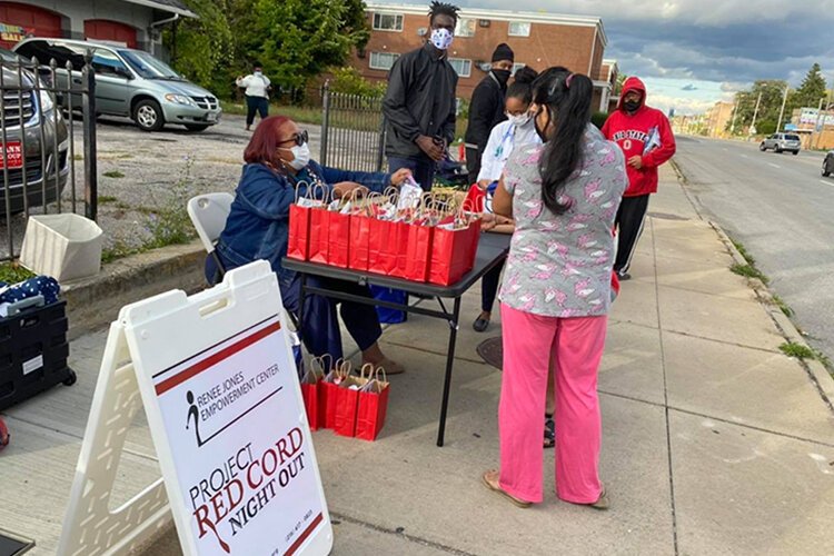 Renee Jones seated at the table with gift bags during a Project Red Cord night out community outreach evening in East Cleveland.