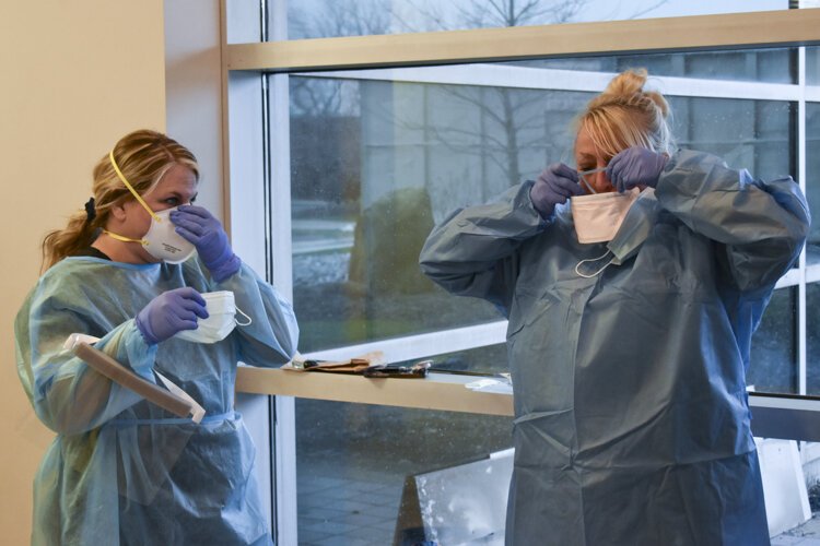 <span class="content-image-text">Nicole McGivern, left, a clinical manager with VNA Ohio,and Sandy Federico, right, a nurse with VNA Ohio, talk as they put on their PPE gear.</span>